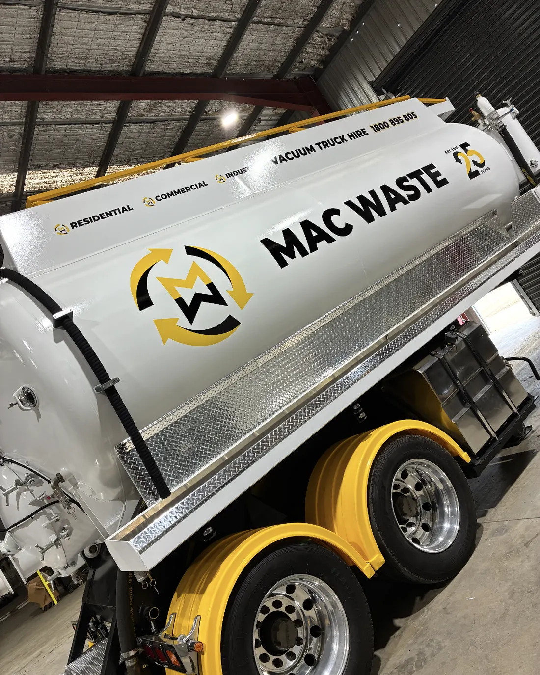 Mac Waste tanker with the tipping body raised inside the depot shed
