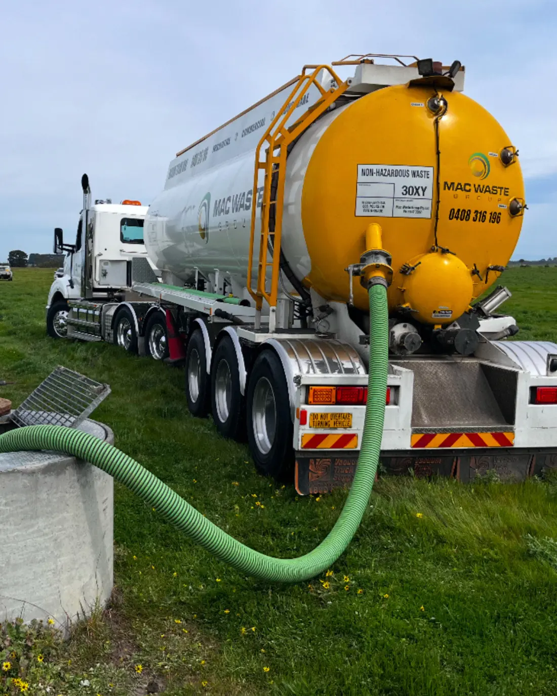 Mac Waste vacuum tanker with suction hose run out on site